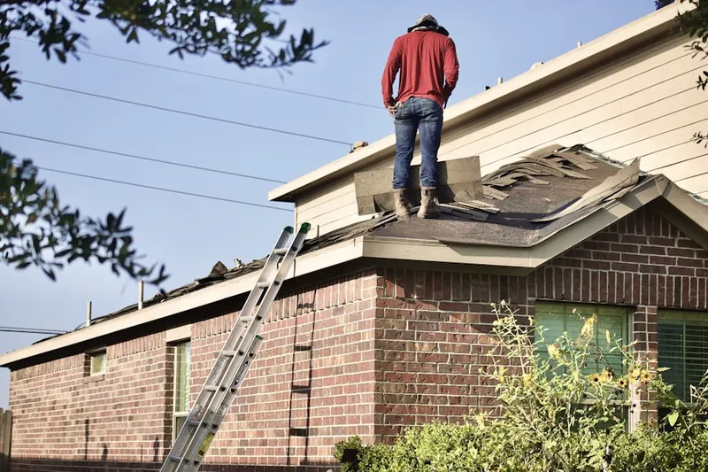Professional roofer working on a residential roof in Brookwood Manor